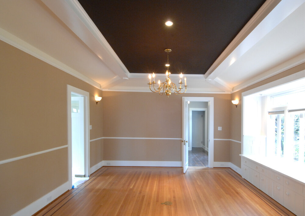 This elegant room consists of a hardwood floor, base mold, chair rail, two sets of crown molding, a tray ceiling, and finally a beautiful chandelier.
