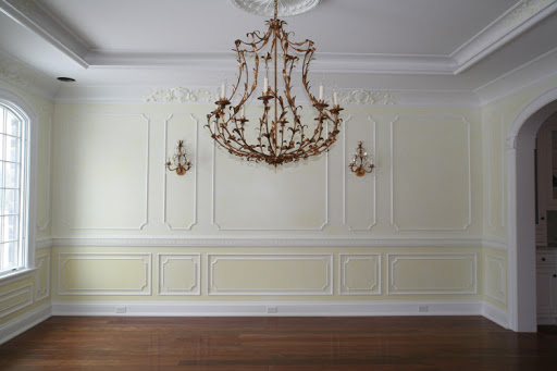 Tray ceiling with crown molding; wall with chair-rail and molding panel; hardwood flooring.